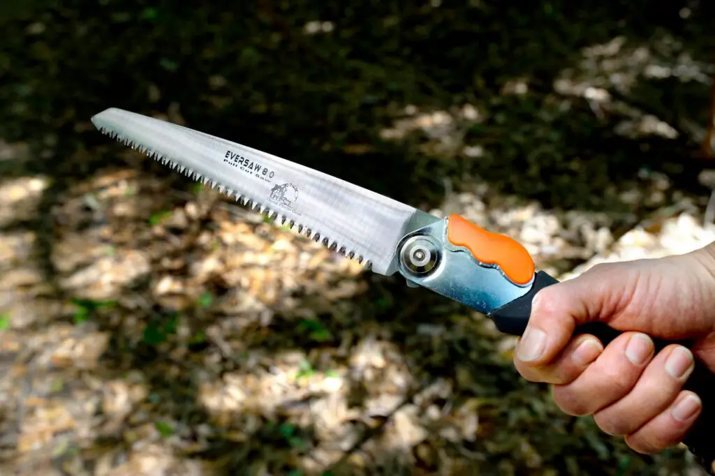 Holding up the Eversaw folding saw, focused on the blade