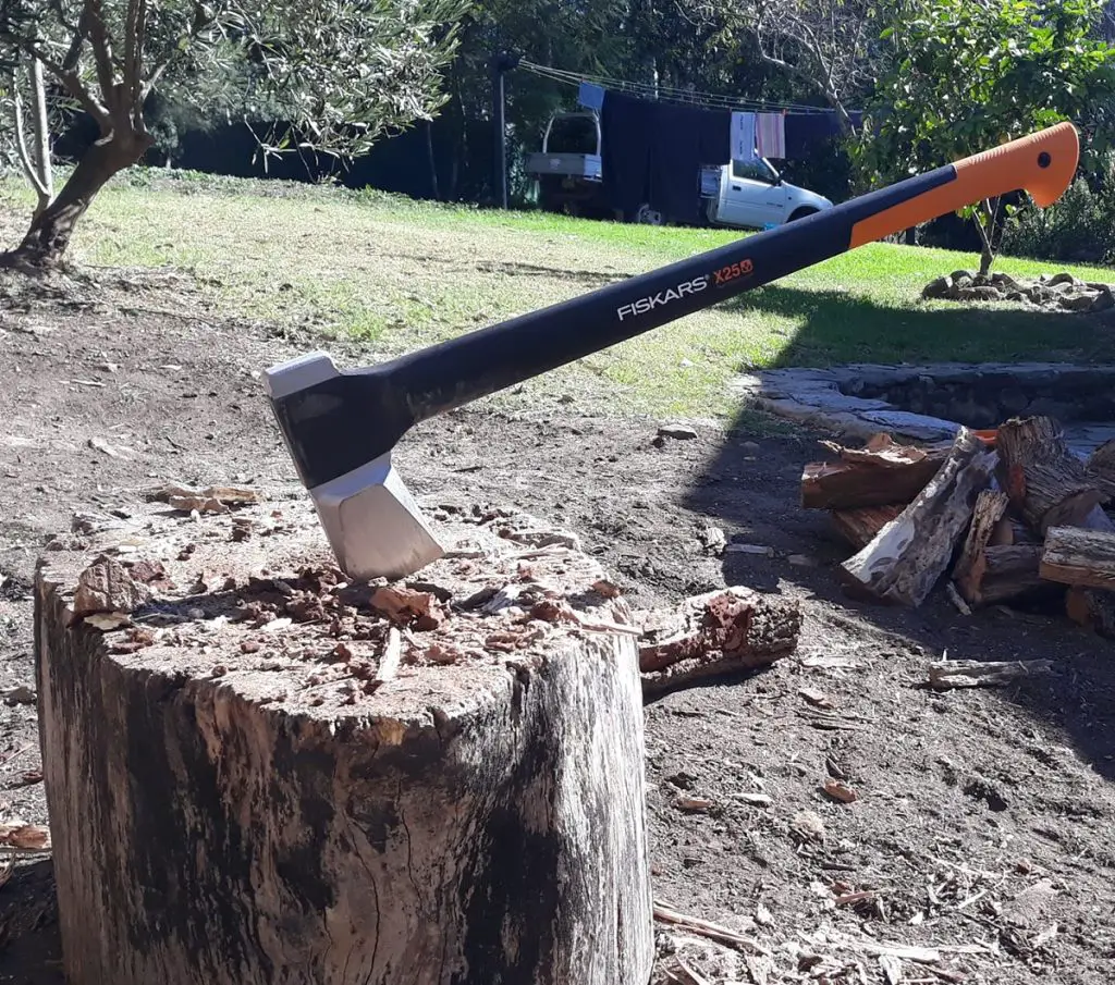 Fiskars X25 splitting axe in a wood chopping block